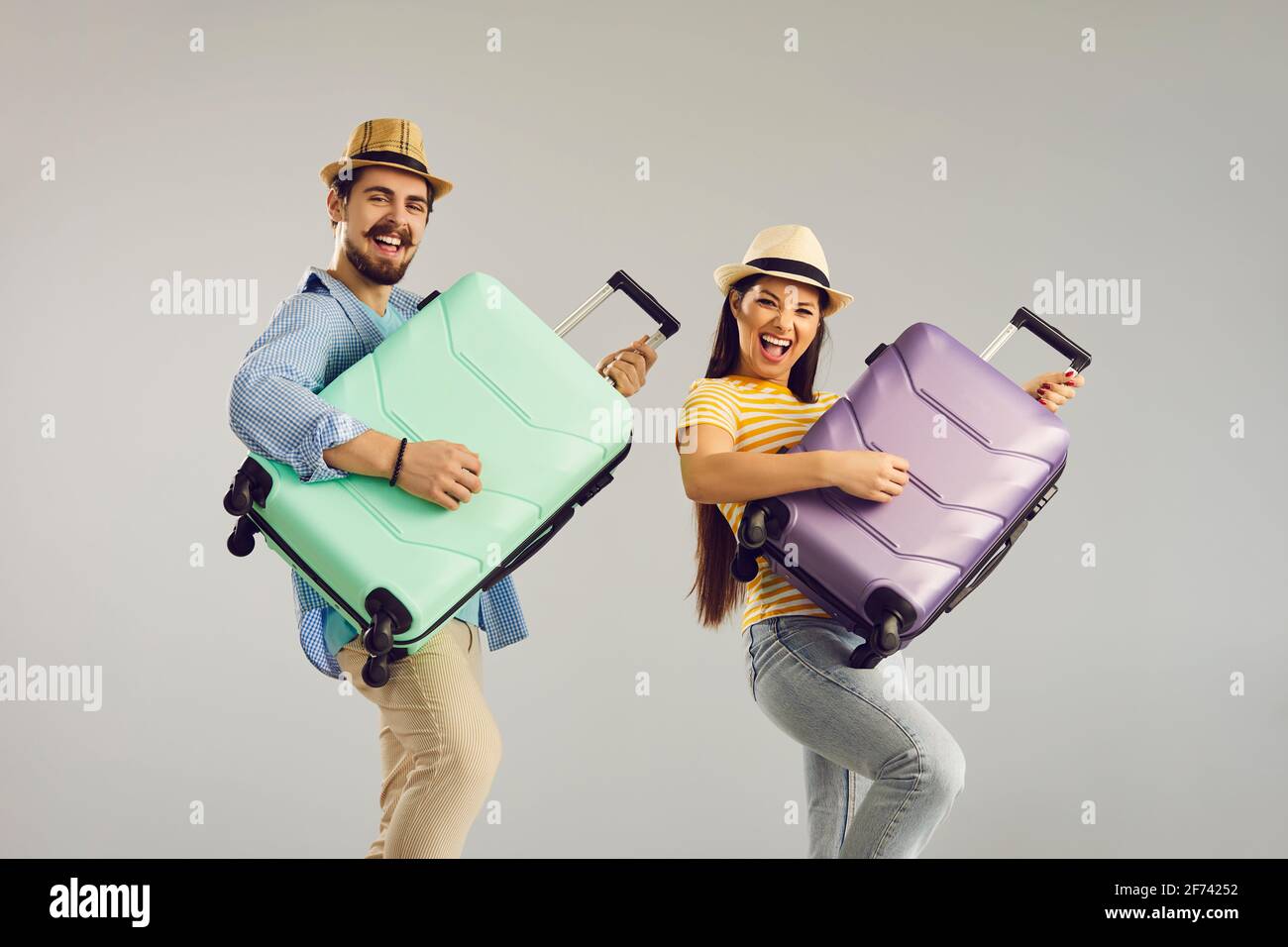 Joyeux drôle de couple touriste jouant sur la valise comme la guitare prise de vue en studio Banque D'Images