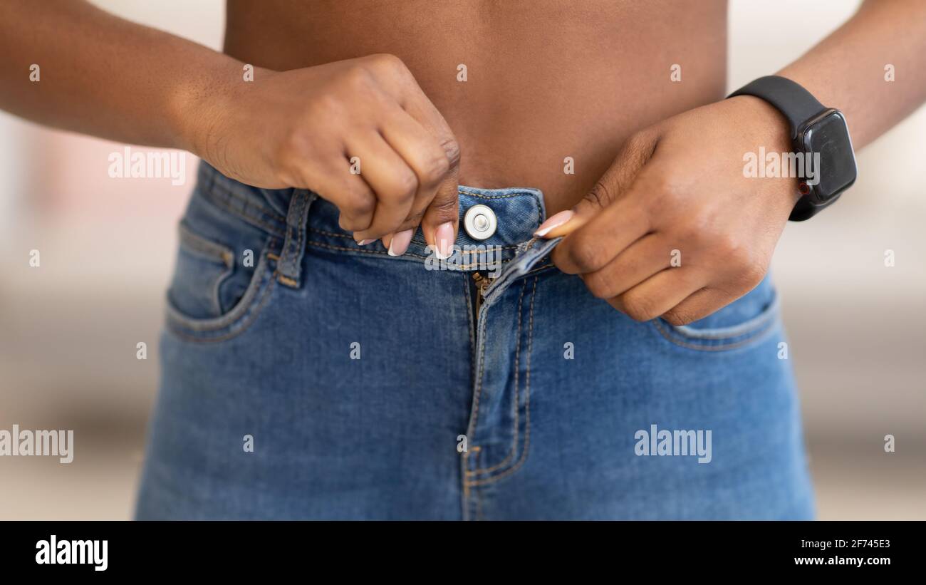 Jean skinny féminin africain fesses après perte de poids à l'intérieur, gros plan Banque D'Images