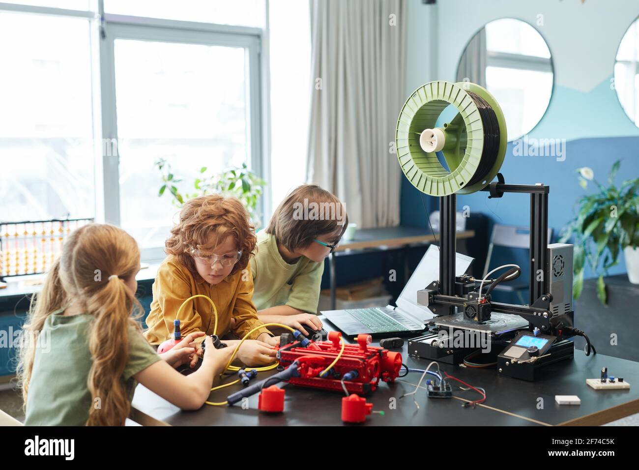 Groupe d'enfants construisant un robot et utilisant une imprimante 3D pendant les cours d'ingénierie à l'école, copier l'espace Banque D'Images