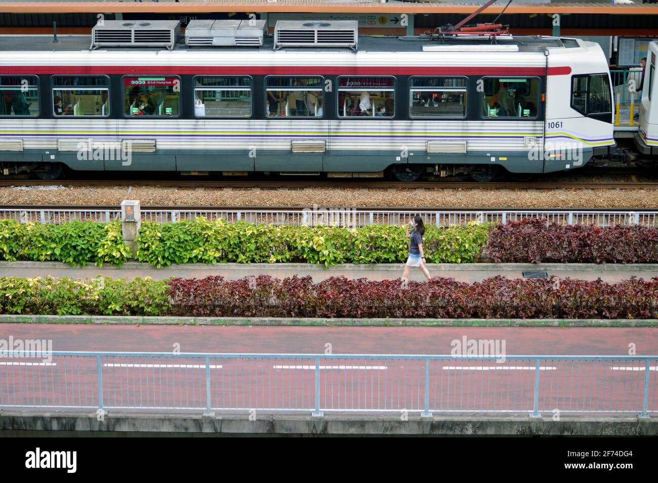 Train léger, trottoir et piste cycelle à Tuen Mun, Hong Kong Banque D'Images