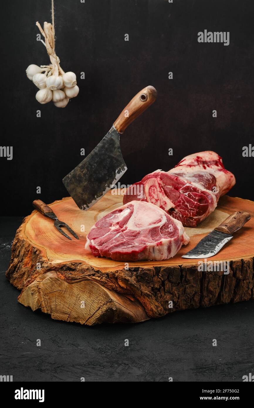 Hacher le steak d'ossobuco de la tige de bœuf avec du couperet sur du bois souche Banque D'Images