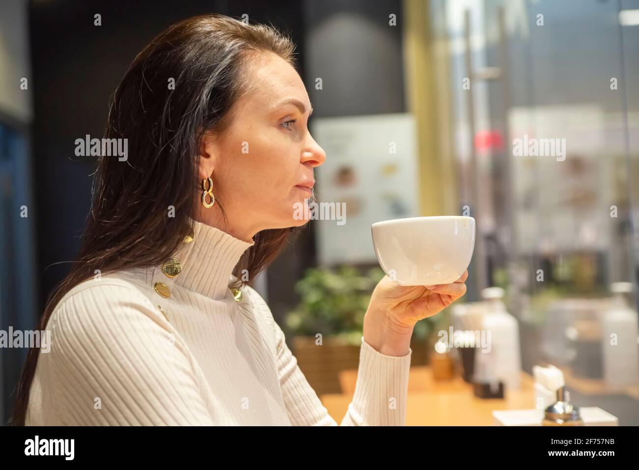 portrait d'une belle femme buvant un café dans un bar un café Banque D'Images