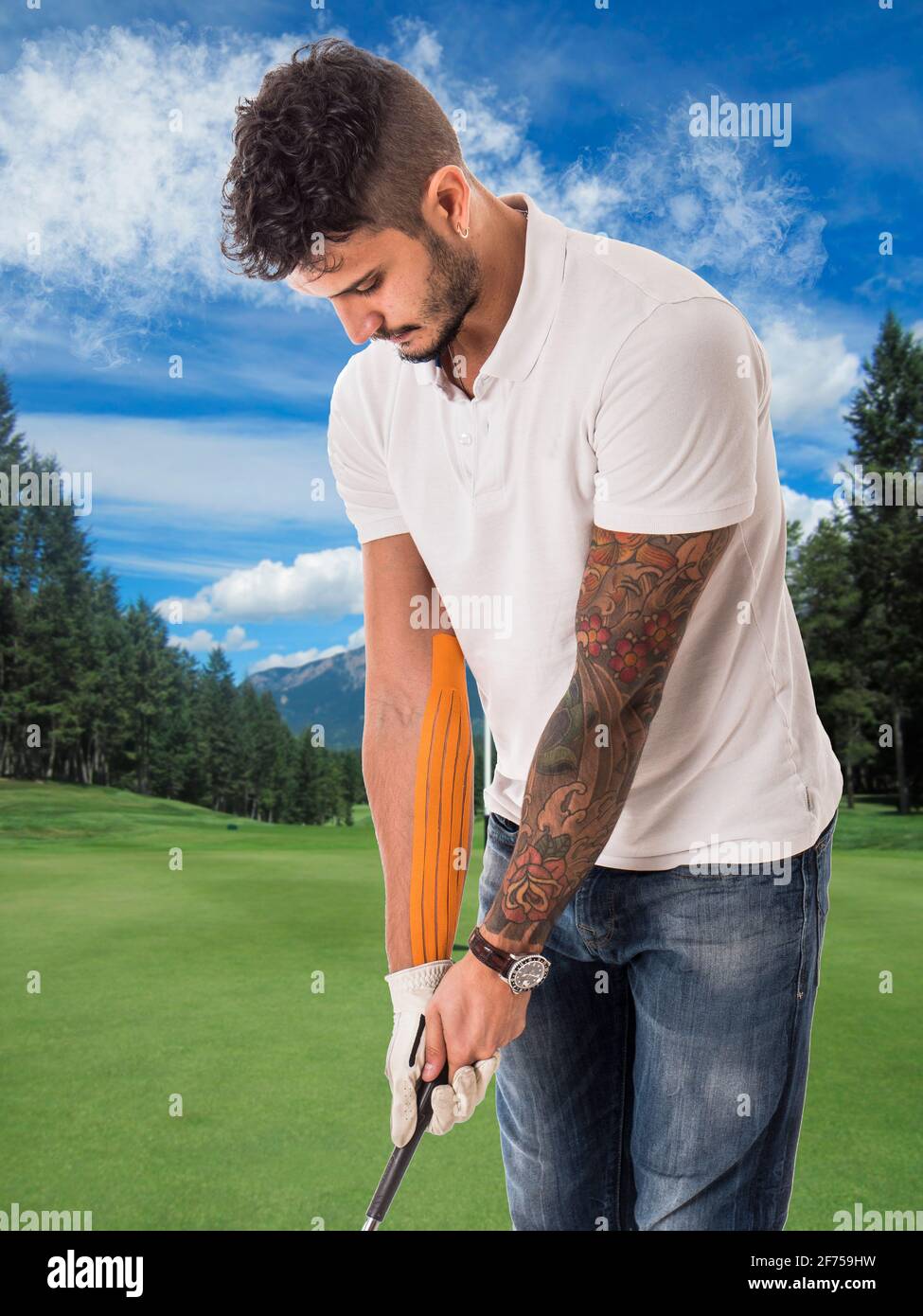 Homme jouant au golf sur un terrain vert avec du ruban adhésif bras Banque D'Images