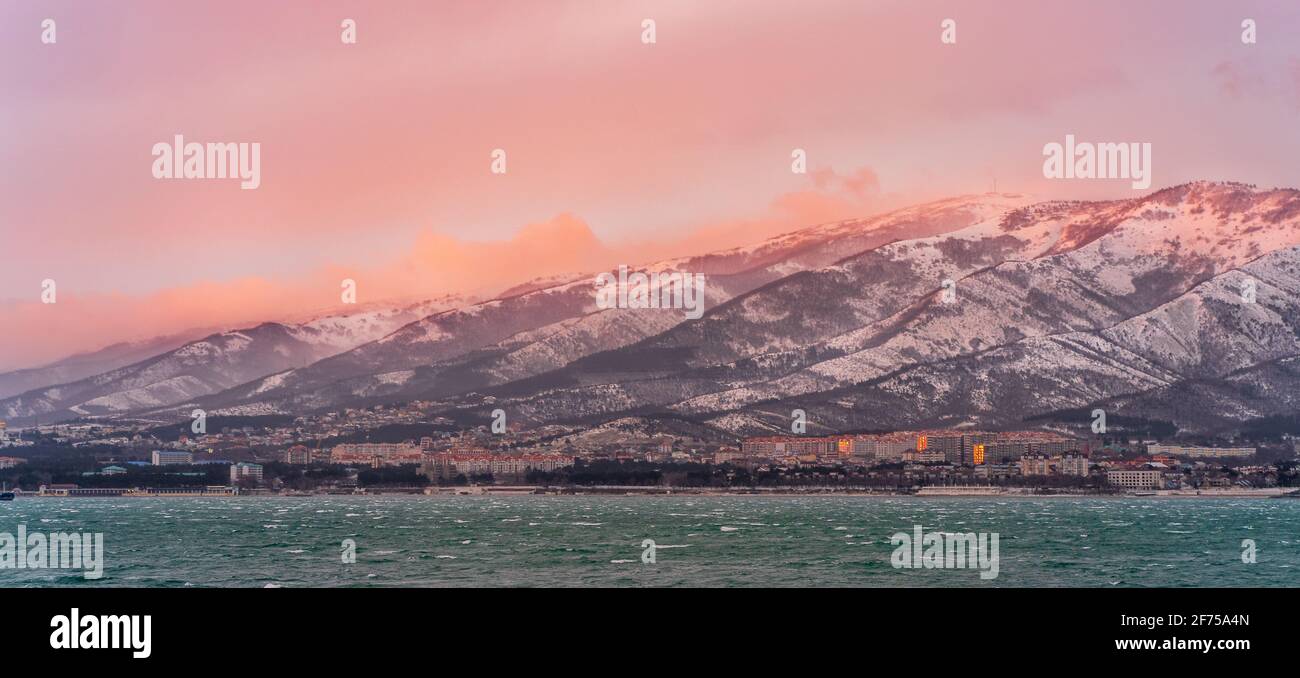 Magnifique paysage de montagne d'hiver avec mer d'azur au coucher du soleil et ciel pittoresque coloré. Banque D'Images