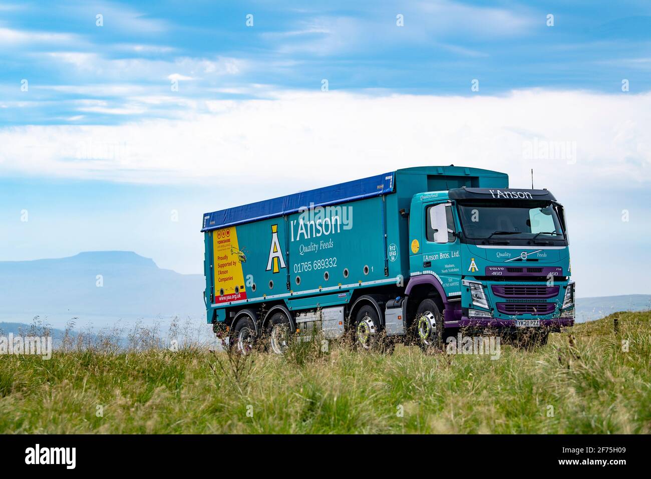 I'anson wagon transportant des aliments pour le bétail voyageant le long d'une route rurale étroite dans le North Yorkshire, Royaume-Uni. Banque D'Images