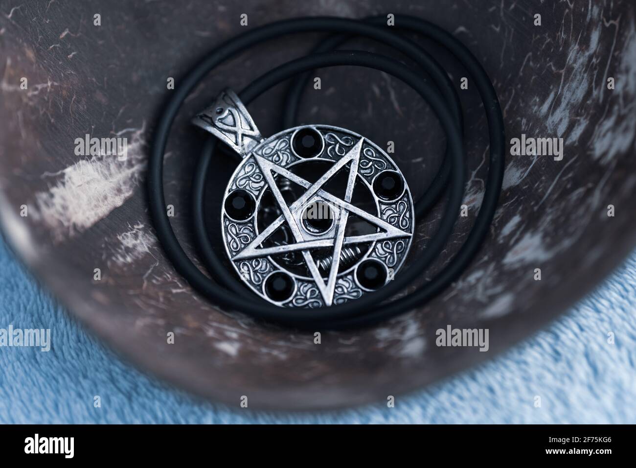 Pendentif Magic Pentagram collier argent et noir acier inoxydable tirer dehors dans un jour d'été gros plan. Banque D'Images