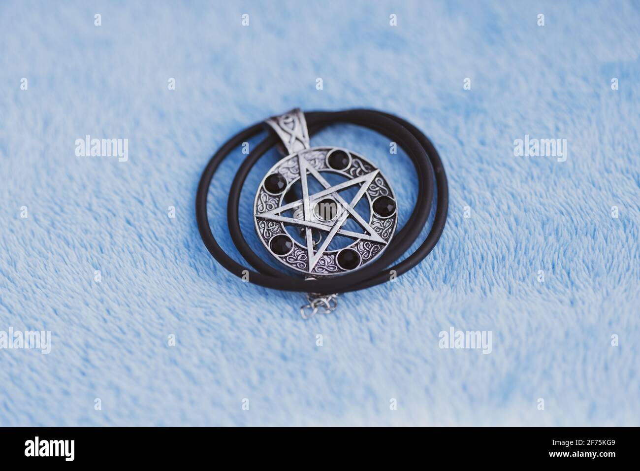 Pendentif Magic Pentagram collier argent et noir acier inoxydable tirer dehors dans un jour d'été gros plan. Banque D'Images