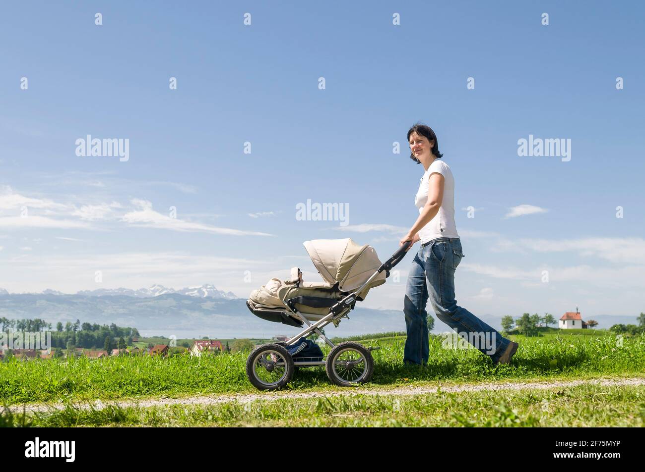 Jeune femme faisant une visite détendue avec son petit fils en poussette Banque D'Images