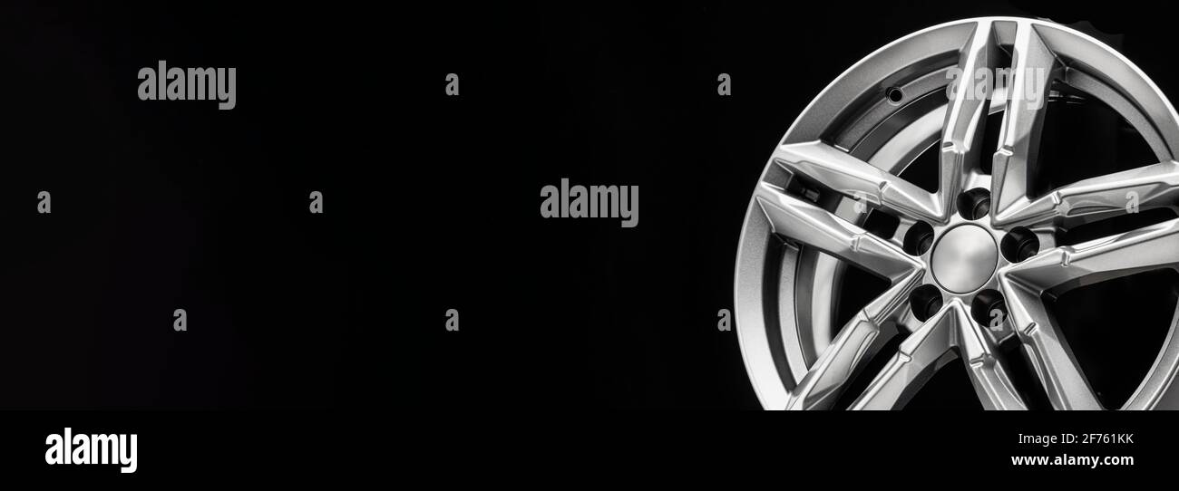 nouvelle roue en alliage argent avec poutres bifurquées sur fond noir, espace de copie, long panoramique. Banque D'Images