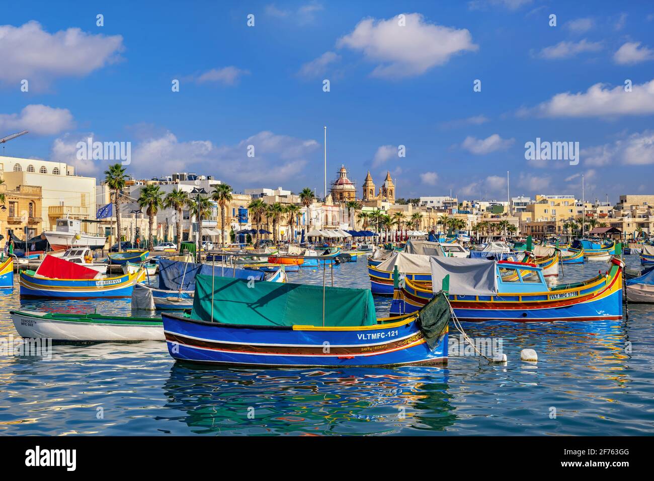 Village de pêcheurs de Marsaxlokk à Malte, gratte-ciel et bateaux maltais traditionnels appelés Luzzu Banque D'Images