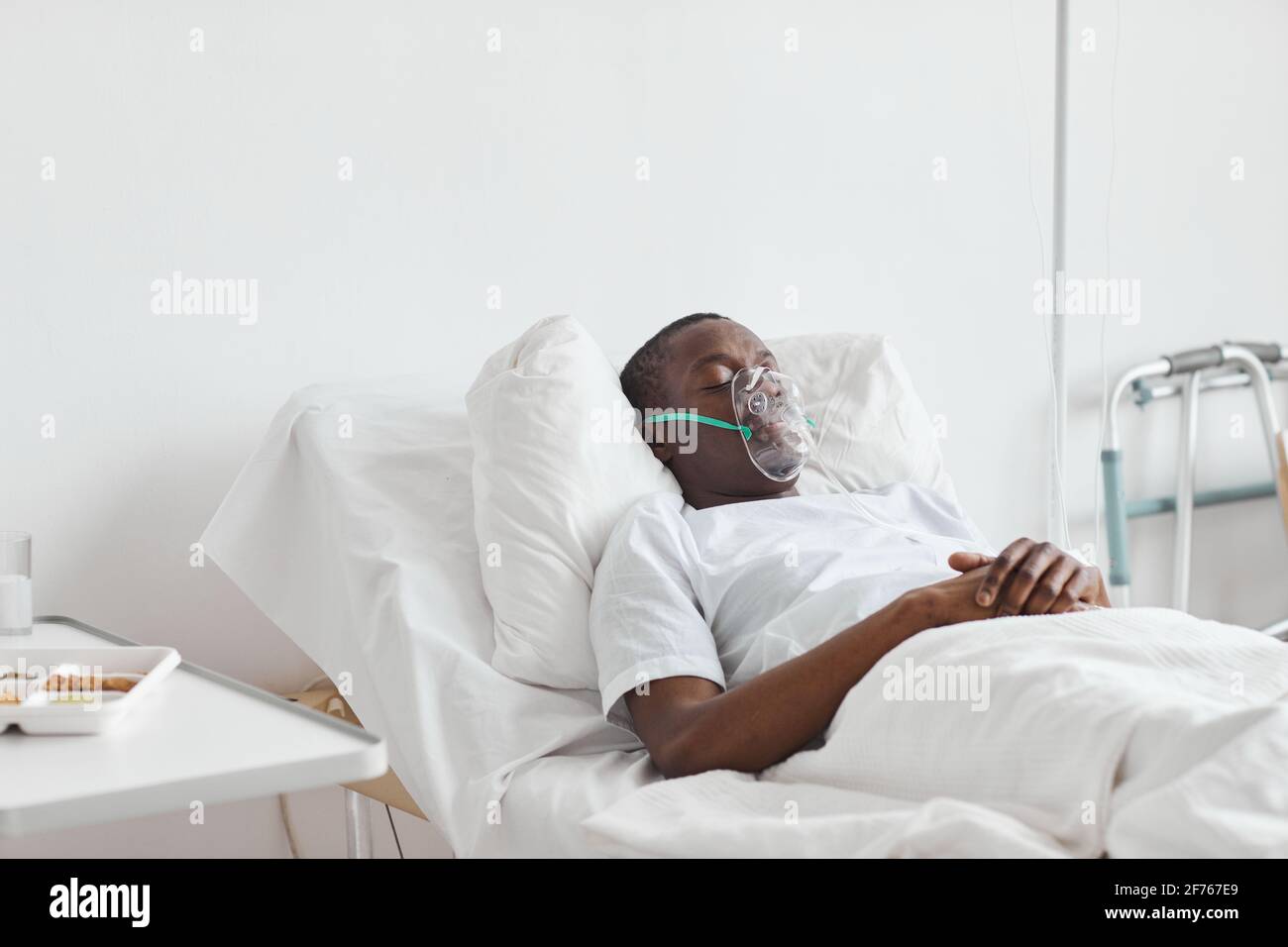 Portrait de l'homme afro-américain dormant sur le lit d'hôpital avec masque  à oxygène dans la salle blanche, espace copie Photo Stock - Alamy