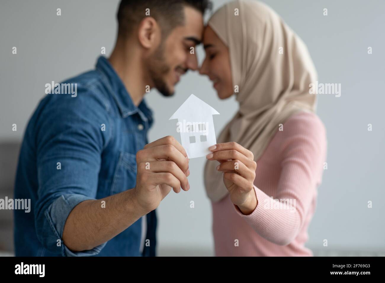 Jeune couple musulman tenant une maison de papier, foyer sélectif Banque D'Images