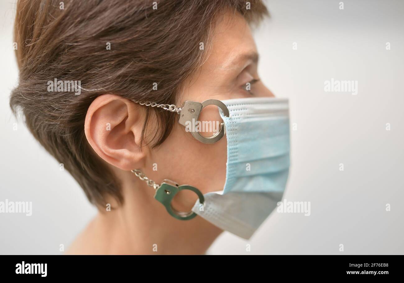 Concept femme avec masque médical verrouillé avec menottes Banque D'Images