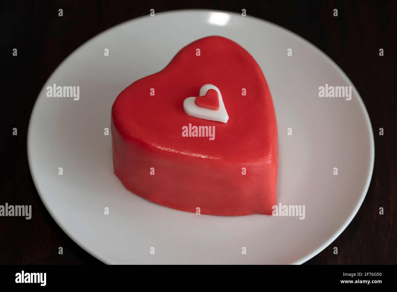 Gâteau au chocolat en forme de coeur sur une assiette sur fond de bois foncé Banque D'Images