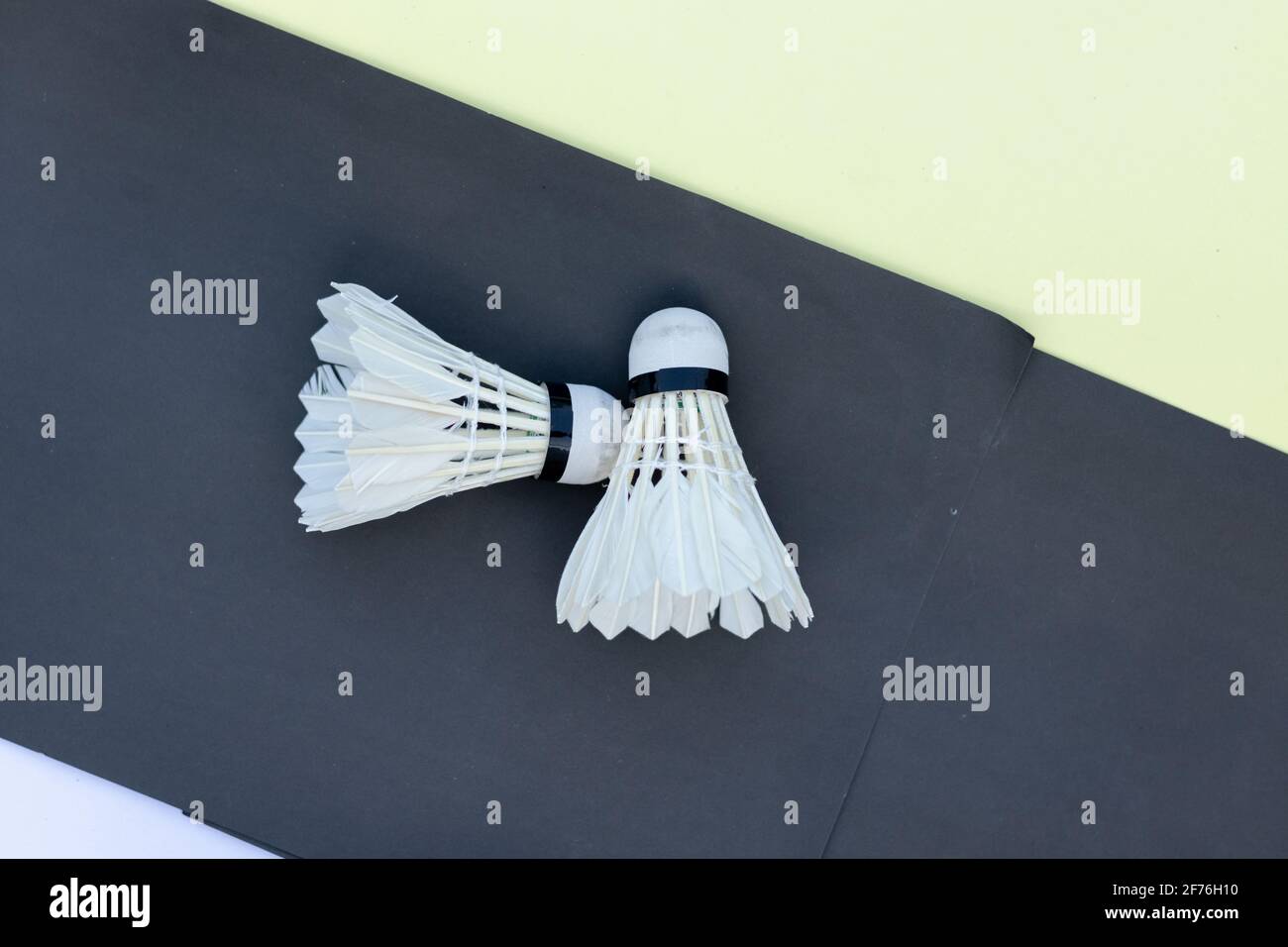 Deux volets en plumes de badminton sur fond de papier blanc jaune et noir  Photo Stock - Alamy