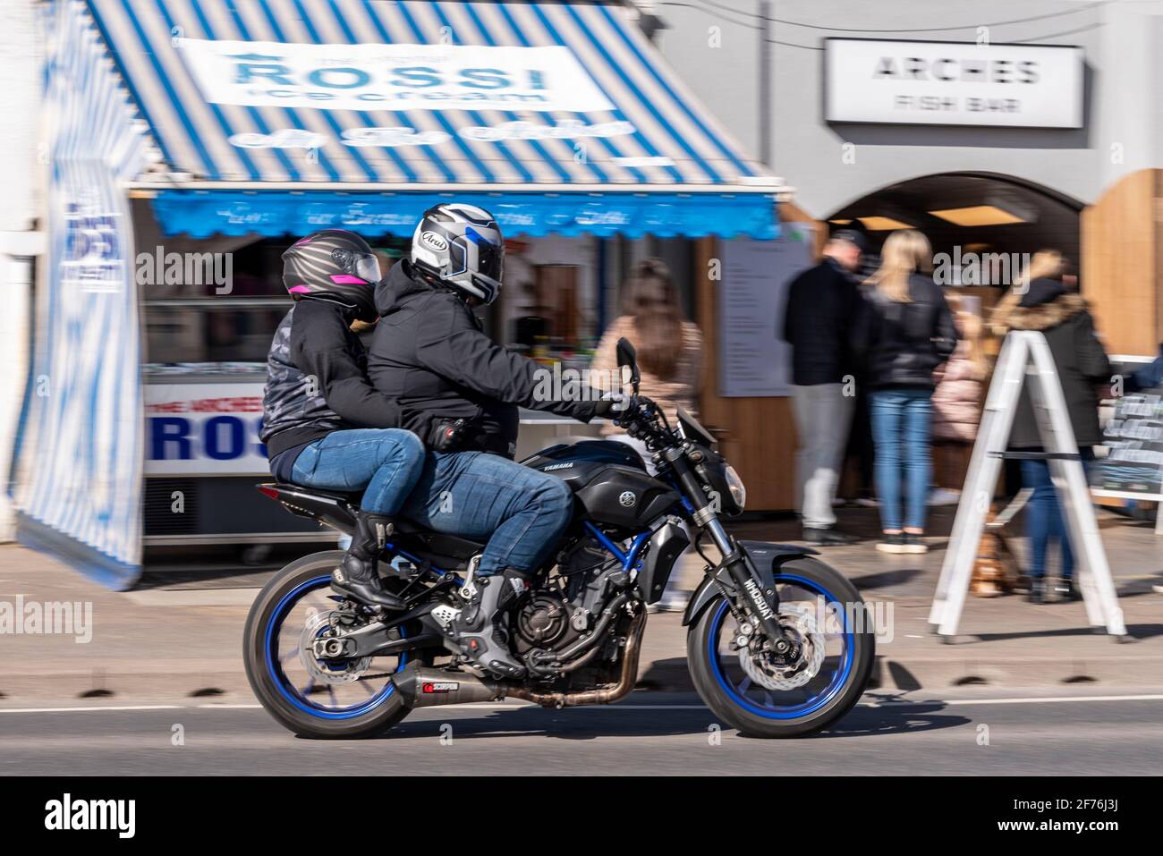 Yamaha Motorcycle Rider, à Southend on Sea, Essex, Royaume-Uni, en passant par les restaurants de cafés à emporter Arches. Pilote de pilolion. Porter un Jean denim Banque D'Images