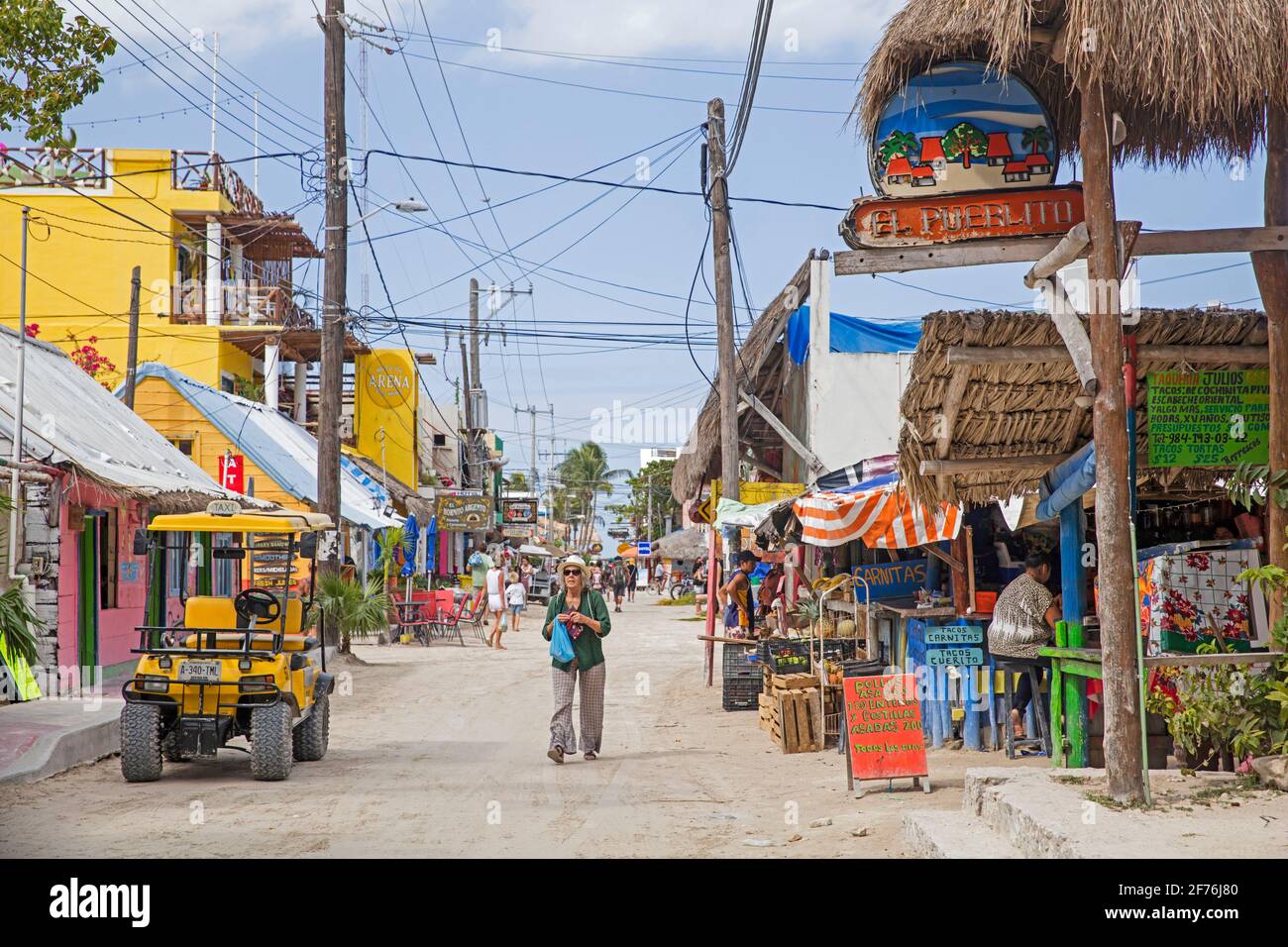 WESTERN touriste marchant dans la rue sur Isla Holbox, île dans l'état mexicain de Quintana Roo, le long de la côte nord de la péninsule de Yucatán, Mexique Banque D'Images