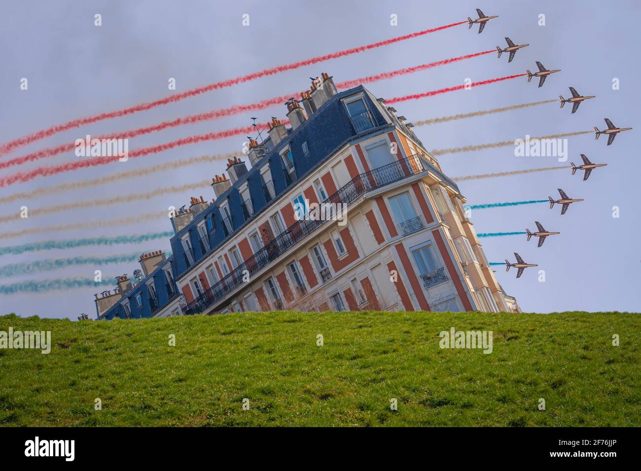 Paris, France - 07 17 2019 : spectacle aérien de juillet 14. Alphajet de la patrouille de France volant derrière un bâtiment Banque D'Images