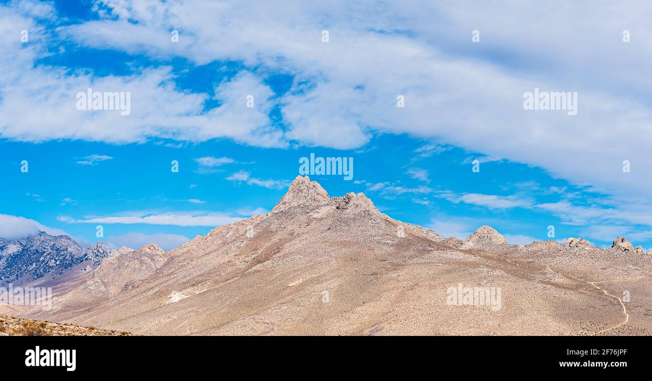 Vue sur la pittoresque montagne désertique brun clair sous un ciel bleu avec des nuages blancs moelleux. Banque D'Images