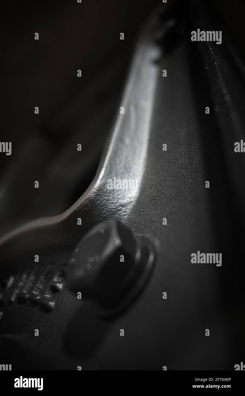 Photo noir et blanc de la patte de table en fer courbé vers le haut dans l'obscurité. Banque D'Images