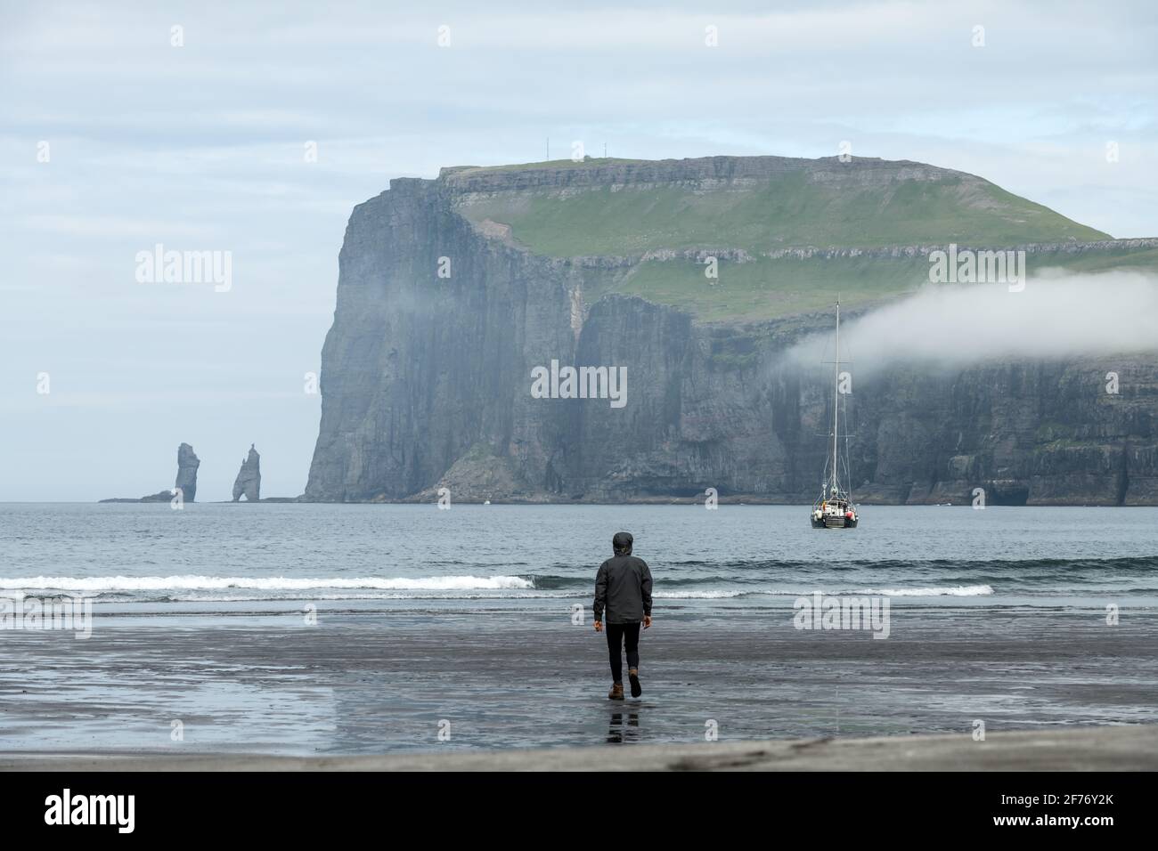Touriste solitaire sur la plage de Tjornuvik sur l'île de Streymoy, îles Féroé, Danemark. Photographie de paysage Banque D'Images