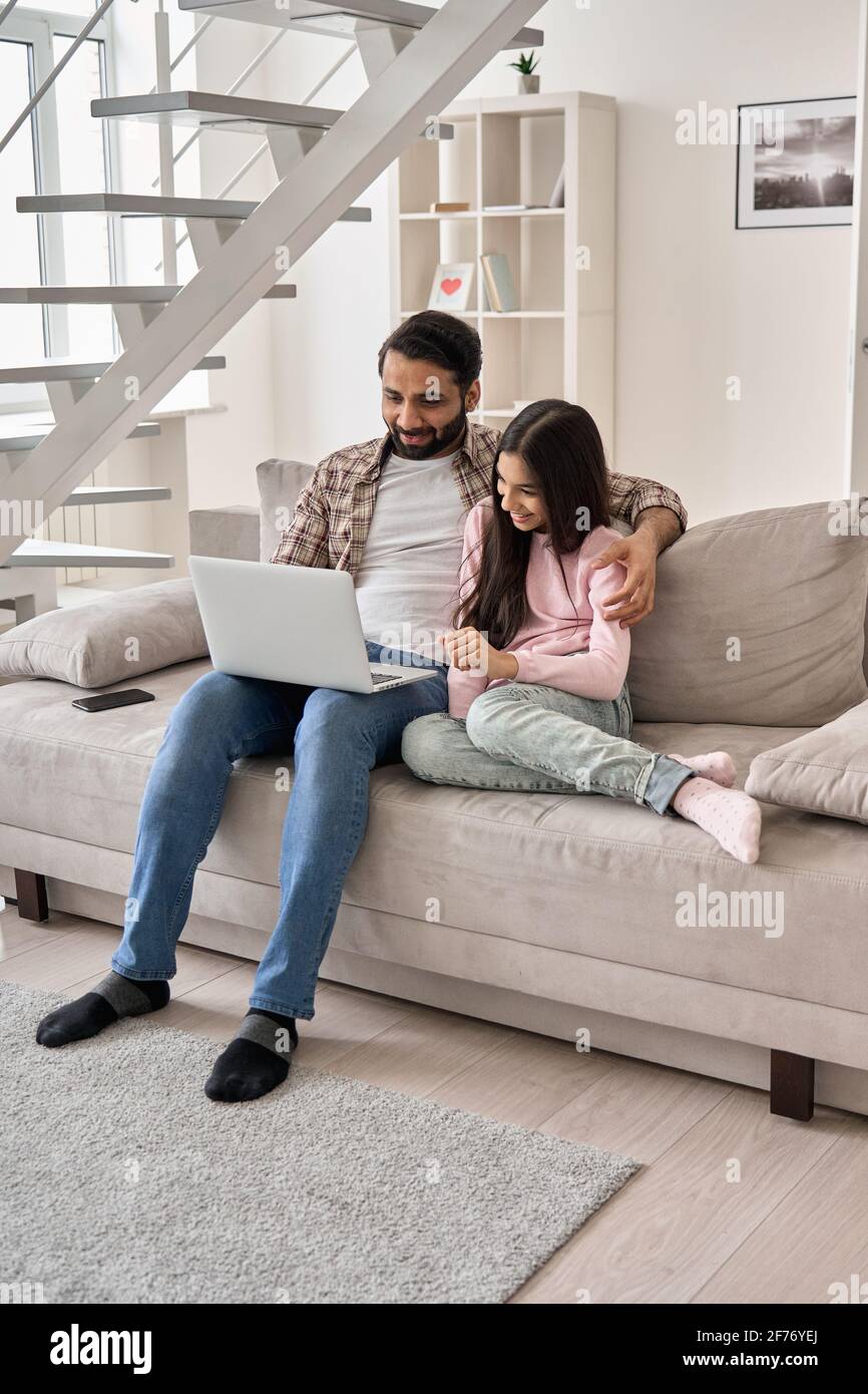 Père indien heureux et fille de l'adolescence utilisant un ordinateur portable à la maison. Banque D'Images