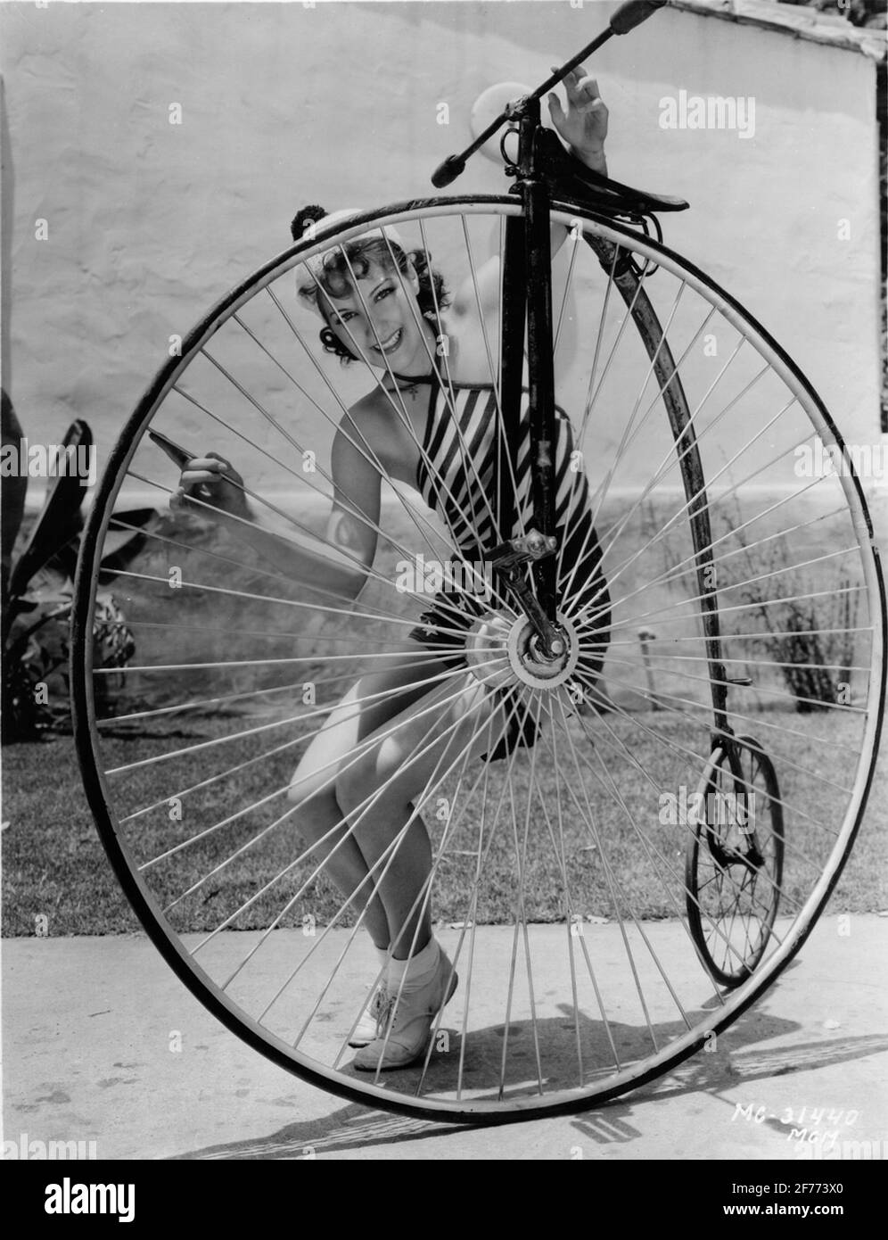 Velociped / vélo. Miss Jean Parker (actrice Metro-Goldwyn-Mayer) a trouvé cette vieille roue dans le stockage du studio et a essayé d'apprendre le cyclisme dans son temps libre. Elle a fait un peu de recherche et a constaté que la roue a été appelée extraordinaire et fabriquée par Singer en 1879. Banque D'Images