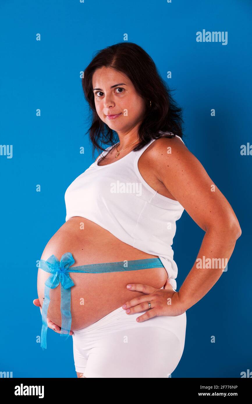 Femme enceinte heureuse avec fond bleu Banque D'Images
