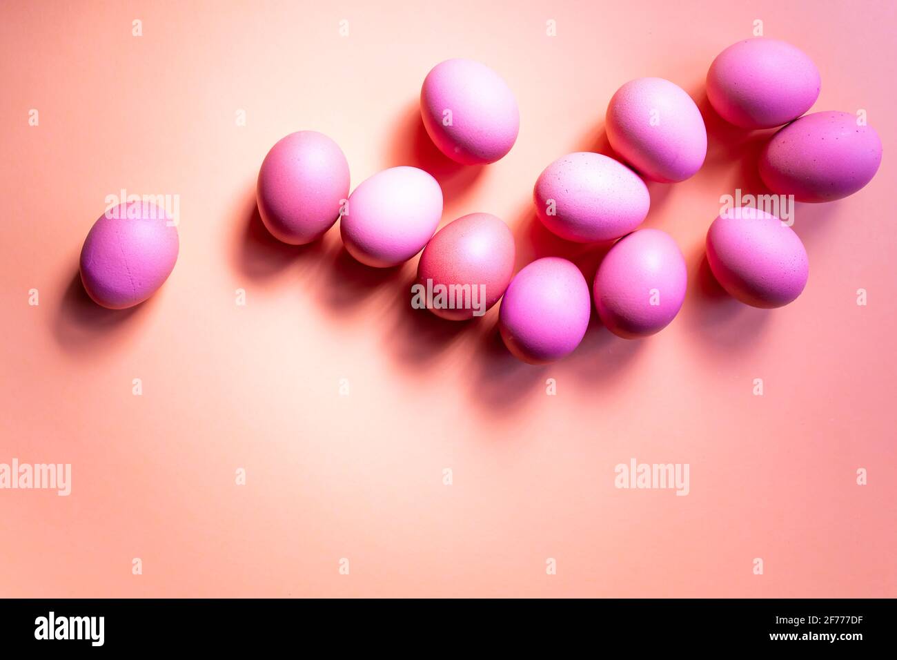 Groupe d'œufs roses isolés sur fond rouge. Concept de Pâques. Banque D'Images