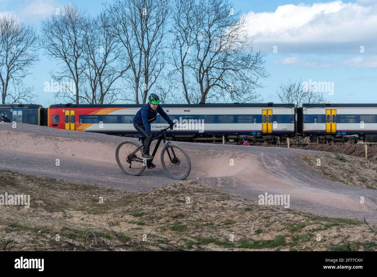 Piste cyclable Mountain et BMX au parc national d'Edenbrook avec piste cyclable, et un train en arrière-plan, Fleet, Hampshire, Royaume-Uni Banque D'Images
