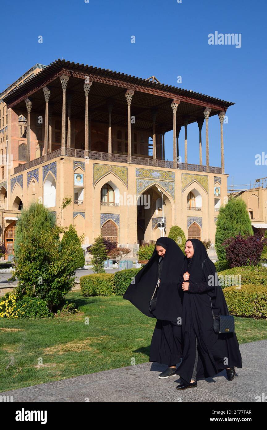 Iran, Isfahan, classée au patrimoine mondial de l'UNESCO, place Naqhsh-e Jahan (place Imam), femmes passant par le palais Ali Qapu Banque D'Images