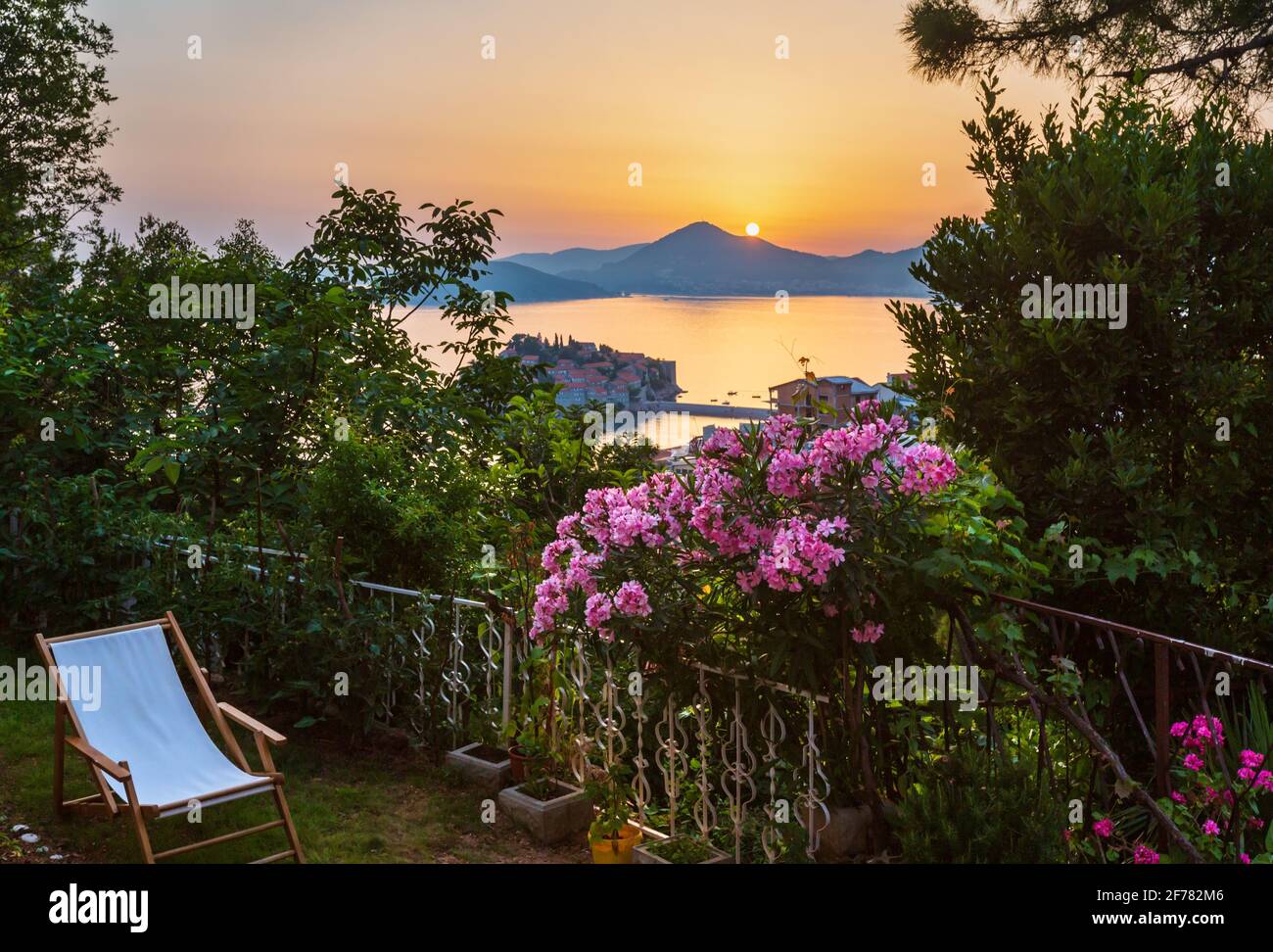 La vue depuis la terrasse au coucher du soleil sur la mer (l'îlot de Sveti Stefan, Budva Monténégro près) Banque D'Images