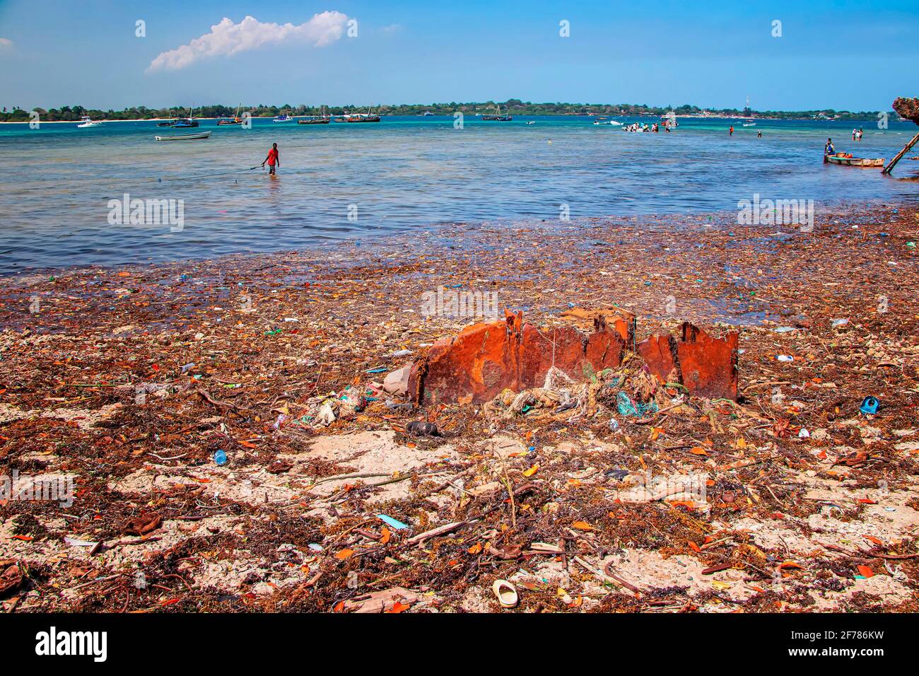 Île de Wasini, Kenya, AFRIQUE - 26 février 2020 : un homme se tient dans les ordures en mer. Ce sont des plastiques dans l'océan Indien. Le bouillons abîme le Banque D'Images