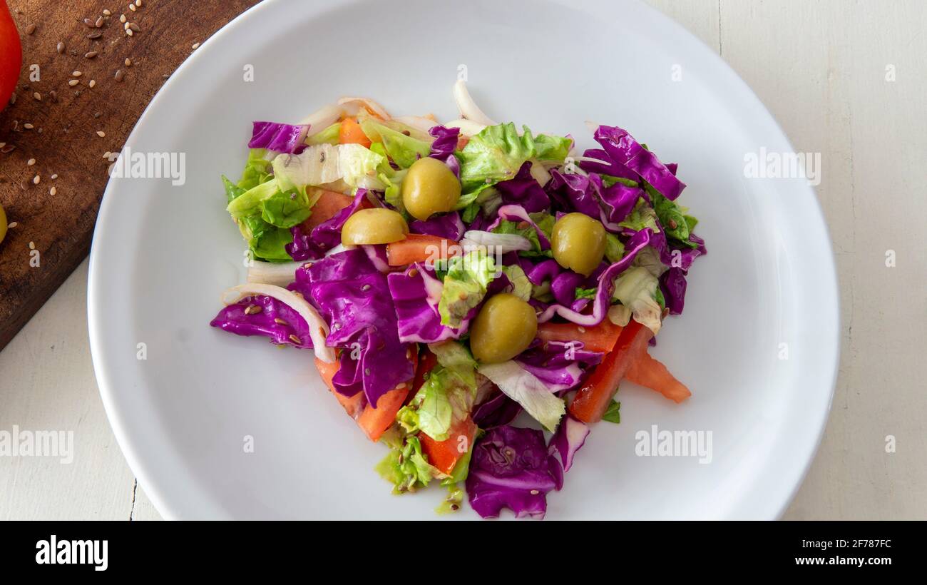 Vue sur une salade méditerranéenne fraîche, placée sur une table blanche Banque D'Images