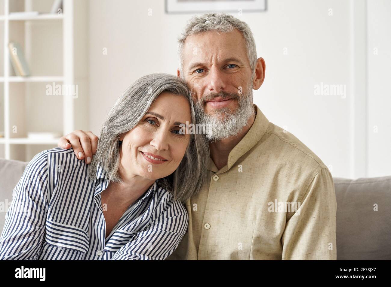 Couple d'âge moyen mûr et heureux, enserrer à la maison. Gros plan portrait. Banque D'Images