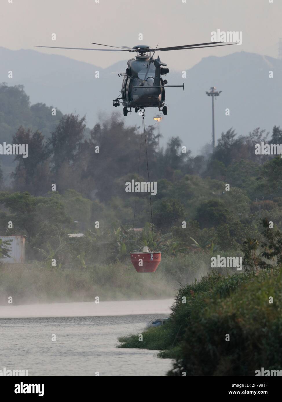 Hélicoptère GFS avec seau à incendie, boucle de la rivière Shenzhen, New Territories, Hong Kong 2 avril 2021 Banque D'Images