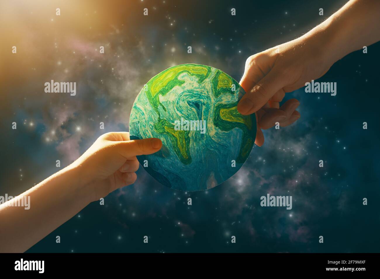 Enfant et adulte tenant la planète entre les mains contre l'arrière-plan de l'espace. Concept de vacances jour de la terre. Banque D'Images