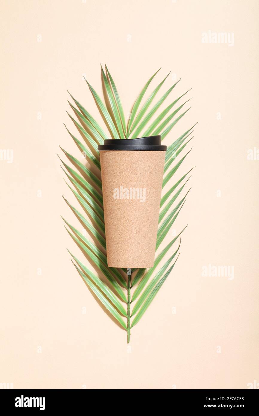 tasse à café ou à thé écologique réutilisable avec branche de paume sur fond beige. Style de vie durable. Concept écologique et zéro déchet. Maquette de pose à plat. Banque D'Images