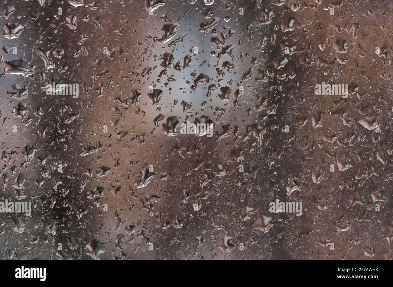 Gouttes de pluie sur la surface d'une vitre sale. Arrière-plan pluvieux avec gouttes d'eau sur le verre de fenêtre Banque D'Images