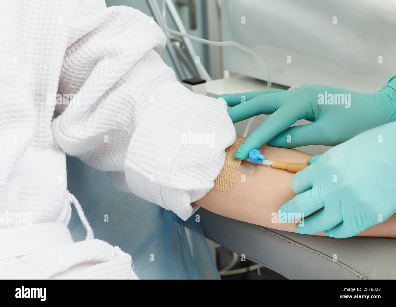 L'esthéticienne insère une aiguille dans la veine d'un patient dans l'ordre prélever du sang pour les procédures cosmétiques et la plasmoliftation Banque D'Images