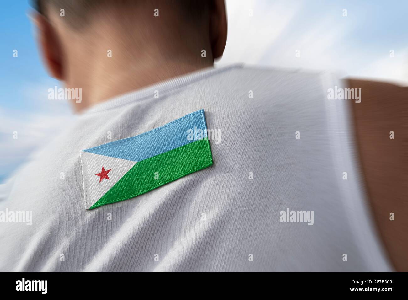 Le drapeau national de Djibouti sur le dos de l'athlète Banque D'Images