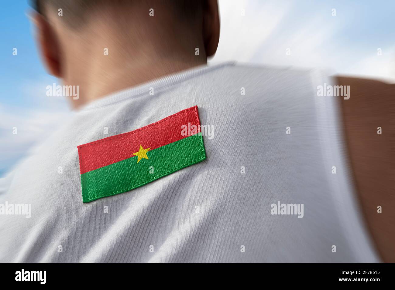 Le drapeau national du Burkina Faso sur le dos de l'athlète Banque D'Images