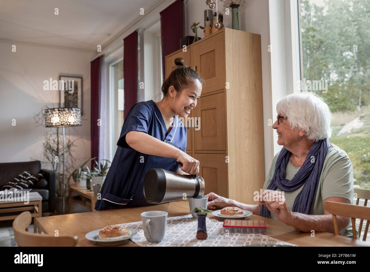 Aide-soignant à domicile préparant une pause-café pour une femme âgée Banque D'Images