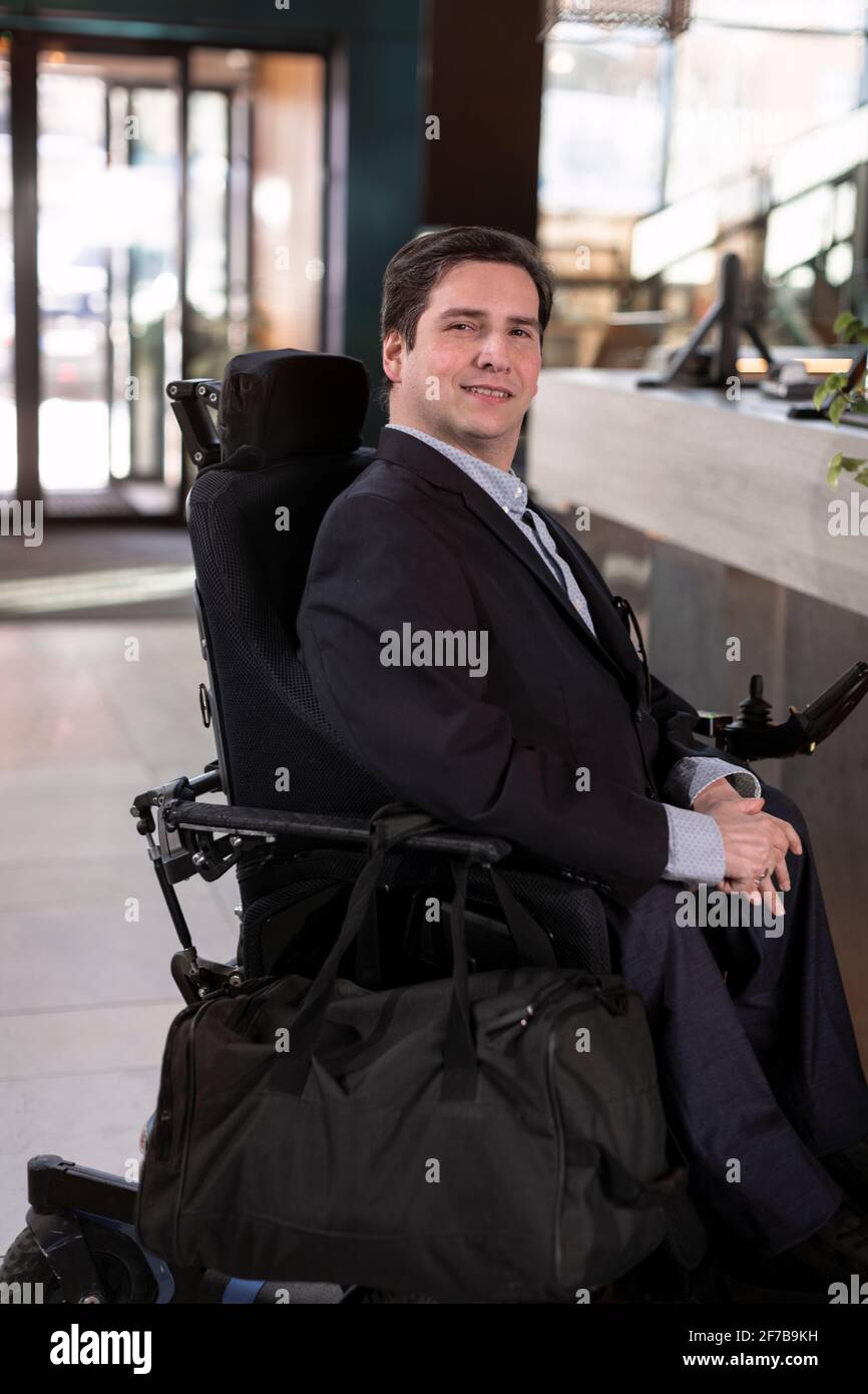 Homme d'affaires en fauteuil roulant dans le hall de l'hôtel Banque D'Images