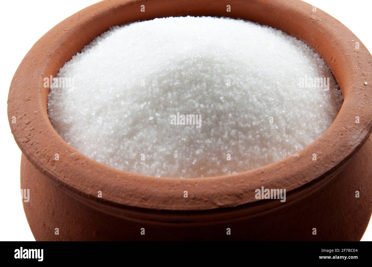 Sucre granulé dans un bol. Cristaux de sucre de table raffiné. Glucides solubles doux. Saccharose, disaccharide de glucose et de fructose. Banque D'Images