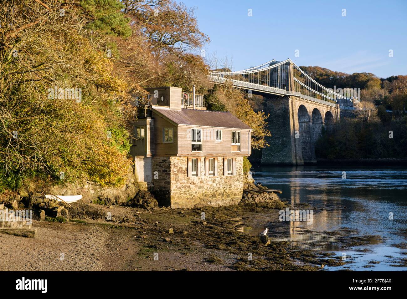 Chalet de vacances Manadwyn et pont suspendu de Menai traversant le détroit de Menai en automne vu de la promenade belge. Menai Bridge Isle of Anglesey pays de Galles Royaume-Uni Banque D'Images