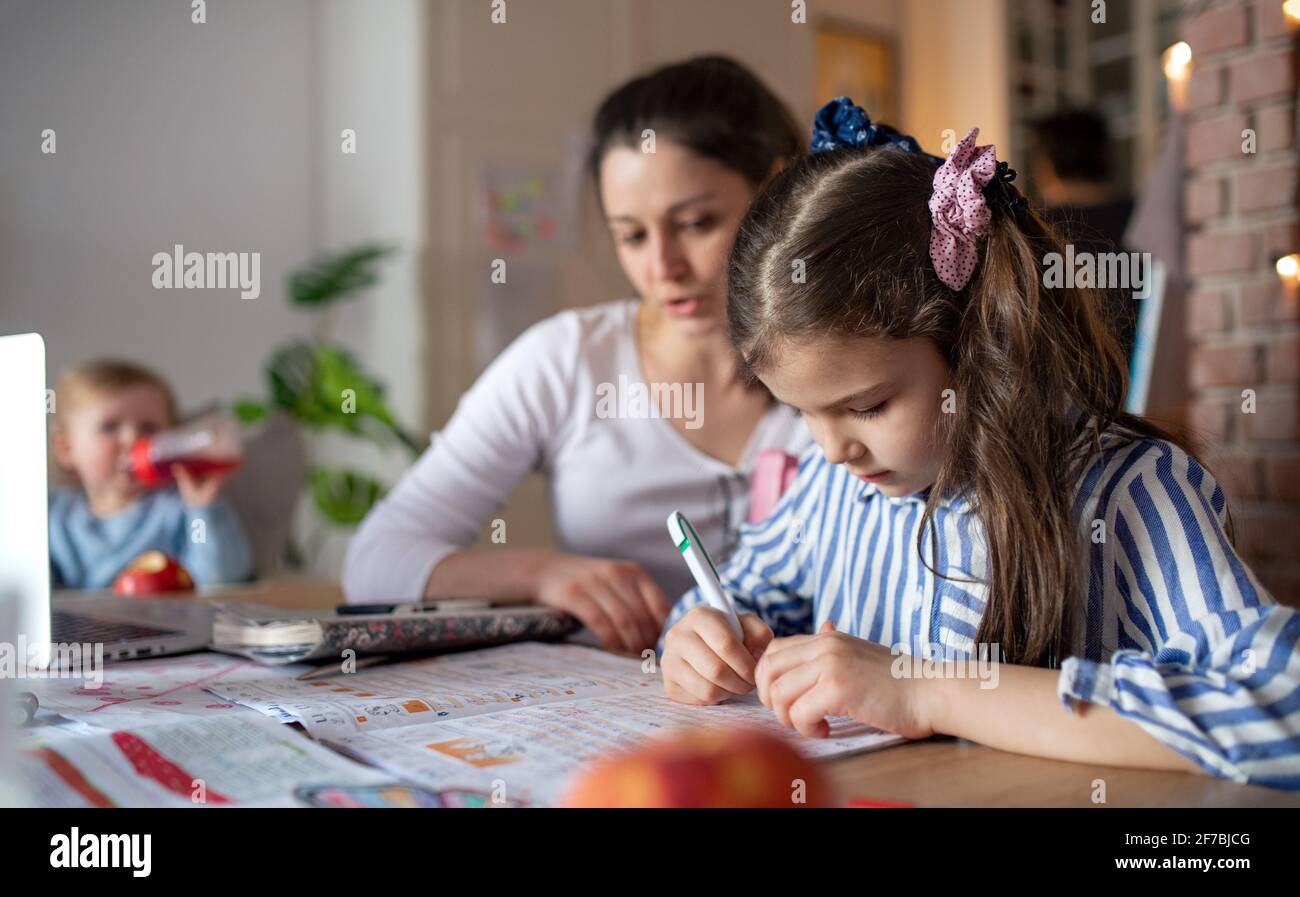 Mère avec petite fille dans la cuisine, école à domicile et concept d'apprentissage à distance. Banque D'Images