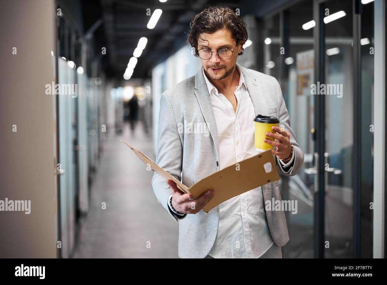 Homme attentif de brunette regardant le dossier ouvert Banque D'Images