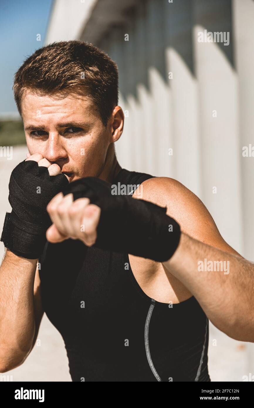 Homme s'exerçant et se battant à l'extérieur, boxeur en gants. Portrait de boxeur masculin Banque D'Images