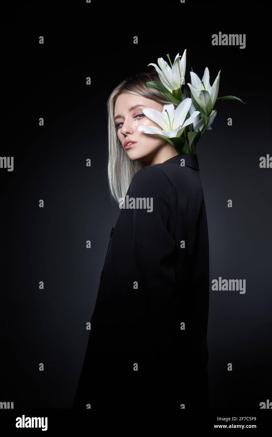 Femme couleur de cheveux d'une blonde avec fleur de nénuphars sur fond noir. Modèle de femme à colorier en couleur de frêne. Portrait d'une fille Banque D'Images